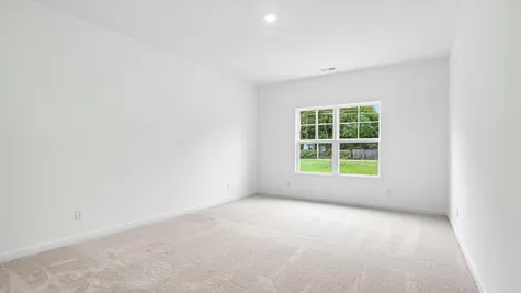 Primary bedroom of the Chestnut by Arbor Homes with ecru carpet
