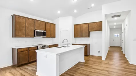 Kitchen of the Chestnut by Arbor Homes with Arid cabinets and a center island