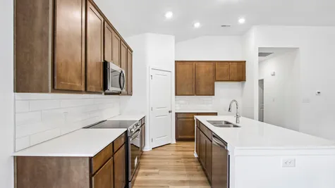 Kitchen of the Chestnut by Arbor Homes with Arid cabinets and a center island