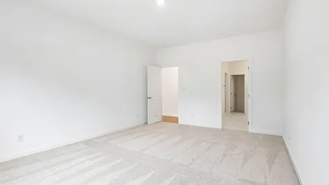 Primary bedroom of the Chestnut by Arbor Homes with ecru carpet